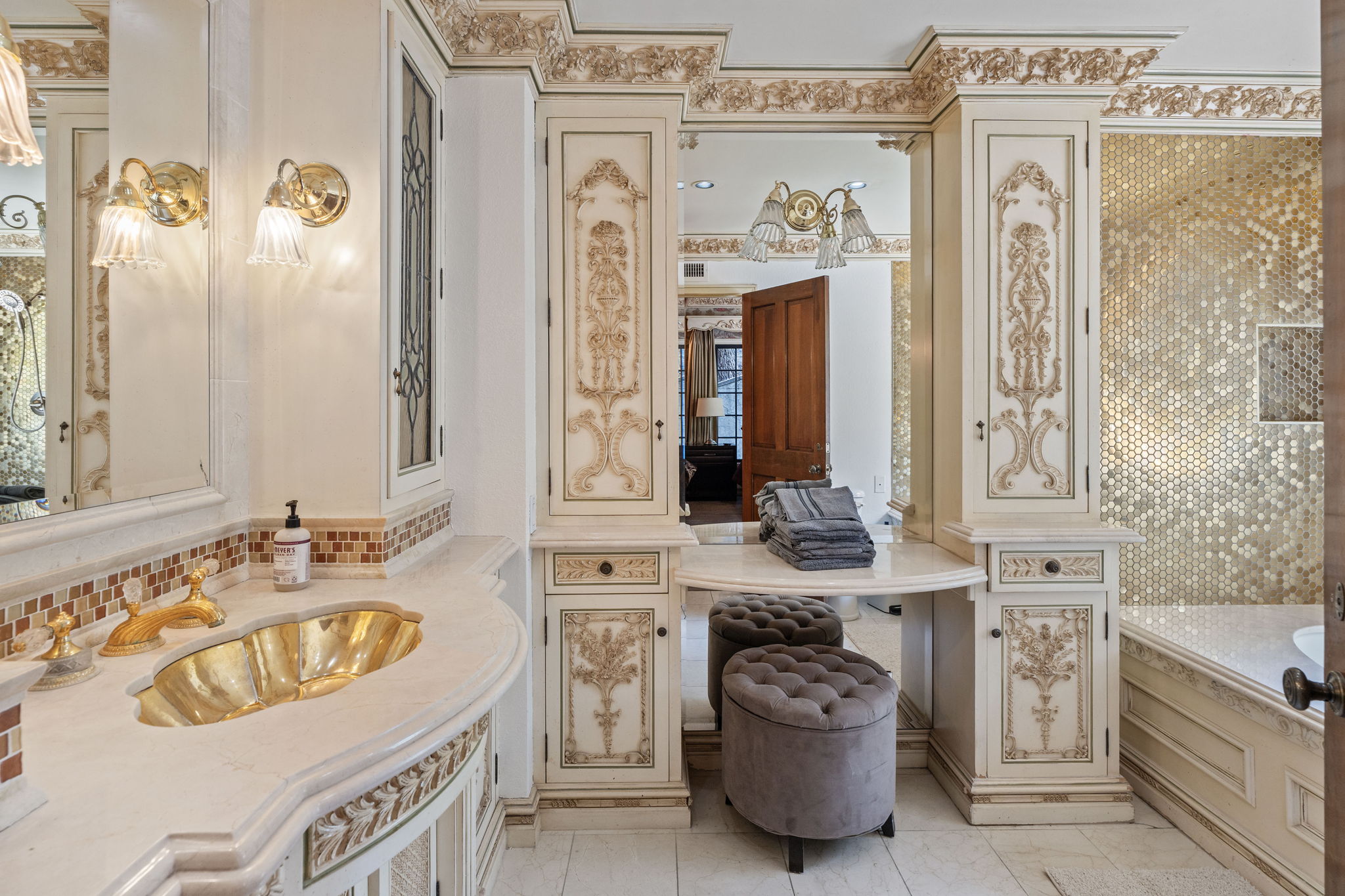 Elegant bathroom with gold vanity fixtures and warm lighting
