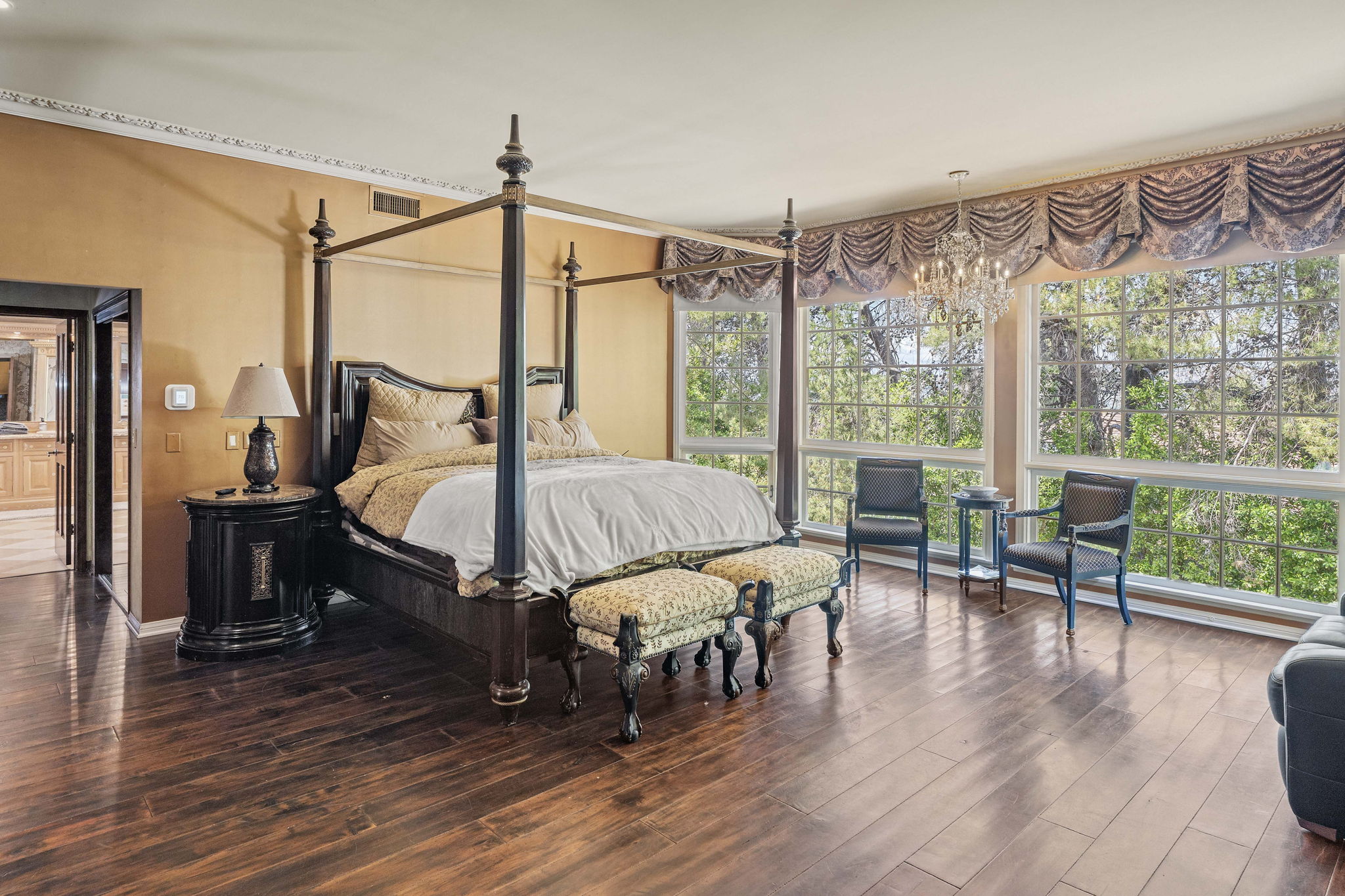 Private suite with a four-poster bed and hardwood floors